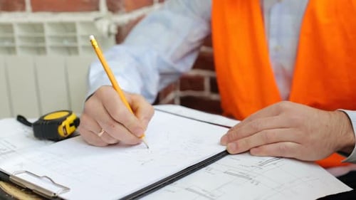 Construction engineer works with blueprints in the office.