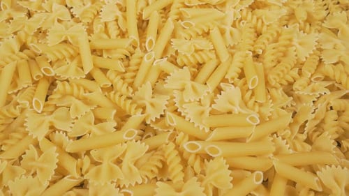 Variety of Golden Dry Pasta Shapes Close Up