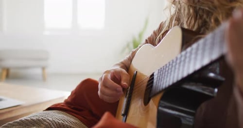 Woman Strumming Acoustic Guitar in Living Room