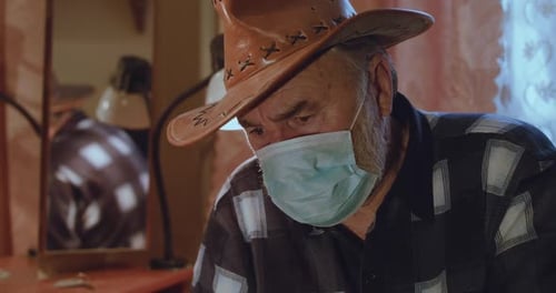 Adult Wearing Mask and Cowboy Hat Indoors