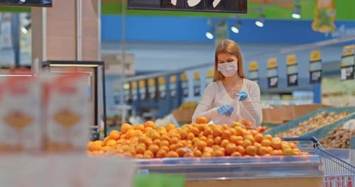 Young Woman Chooses Fruits in the Supermarket