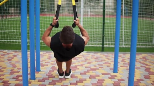 Athletic Man Exercising Outdoors with Suspension Straps