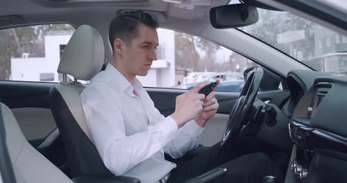 Excited Man Using Phone in Car after Good News