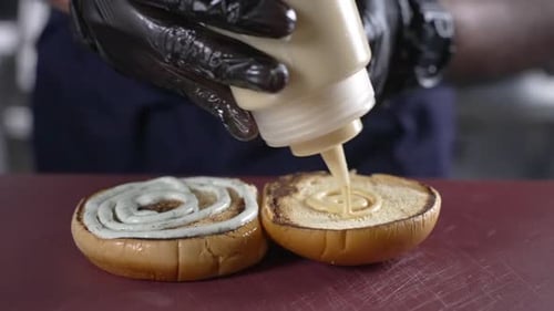 Sauce Being Applied to Burger Bun Halves
