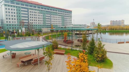 Tables and Benches Under Roofs on Wooden Ground Over Pond