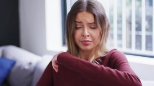 Femme éternuant sur son coude