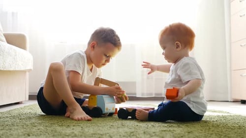 Two Children Playing With Wooden Truck Toy