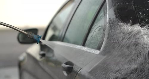 Washing the side of a dark grey car
