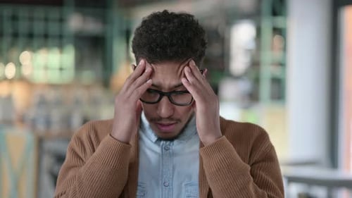 Man Rubbing Forehead in Discomfort Close Up