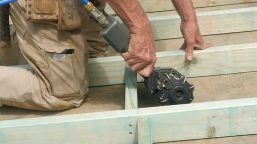 Experienced Housing Frame Carpenter Uses Nail Gun On Site