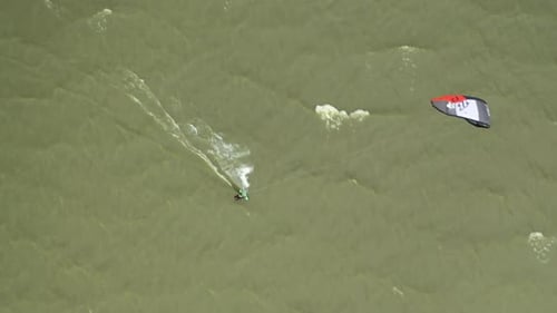 AERIAL: Extreme Water Sport and Summer Vacations Concept - Professional Kite Surfer on the Sea Wave