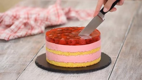 Cake with Strawberry Topping Being Cut with Knife
