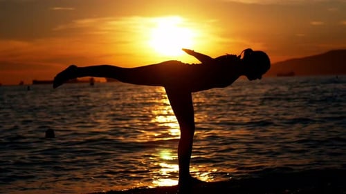 Woman performing yoga on the beach