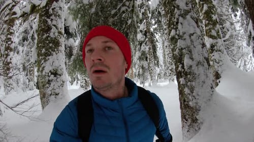 Entschlossen fitter Mann wandert in verschneiter Winter-Wildnis mit Vlog-Kamera