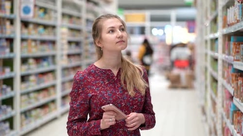 Attractive Young Woman Choosing Products in Supermarket Marketplace