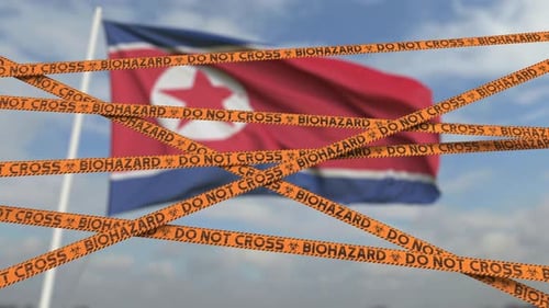 No cruce las líneas de cinta de peligro biológico y la bandera de Corea del Norte