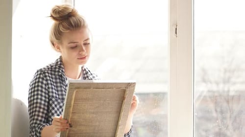 Woman Painting on Canvas by Window Light