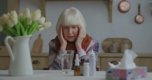 Senior Woman Taking Medicine for Cold at Home