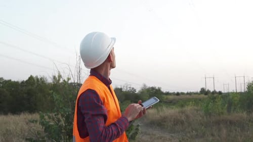 Engineer Uses Tablet Near Rural Powerlines