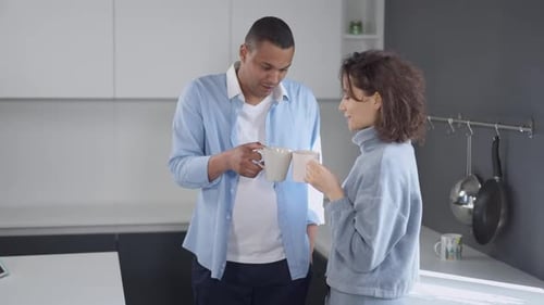 Couple Conversing Over Coffee in Kitchen