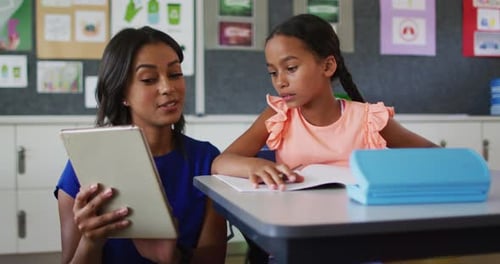 Teacher Working with Elementary Student in Classroom