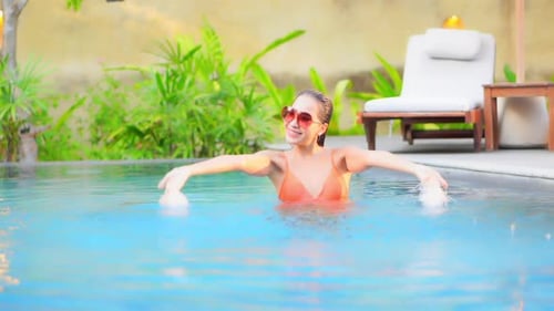 Young asian woman enjoy around outdoor swimming pool for leisure