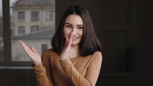 Woman Smiling and Clapping in Her Home