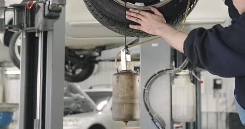 Mechanic Draining Old Brake Fluid From A System. Detail Shot Of The Jar
