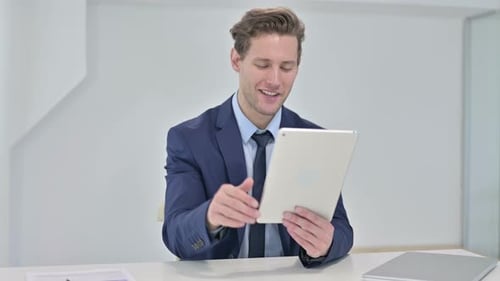 Young Businessman Doing Video Chat on Tablet in Office