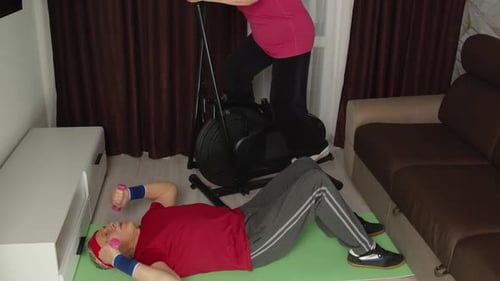 Senior Woman Exercising on Elliptical Machine at Home