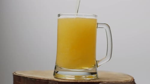 Golden Beer Pouring into a Clear Glass Mug