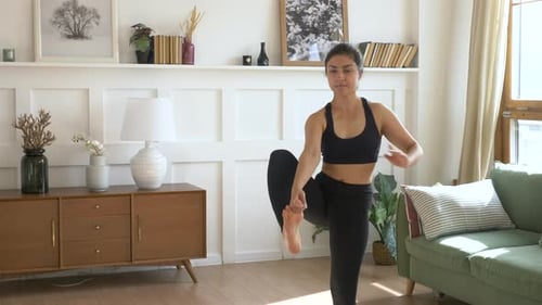 Woman Demonstrates Yoga Pose in her Living Room