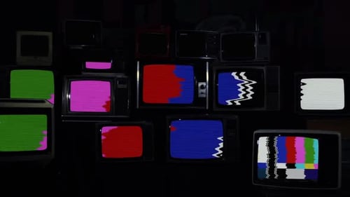 Many Vintage Televisions Displaying Colorful Static and Signals
