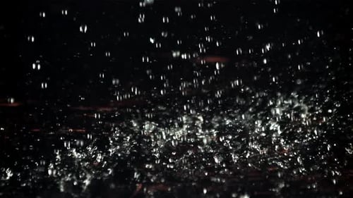 Rain Drops Falling onto a Dark Surface