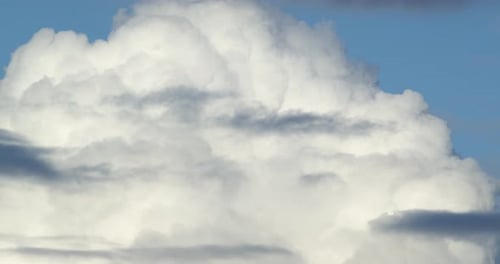 Fluffy White Clouds Moving Across a Blue Sky