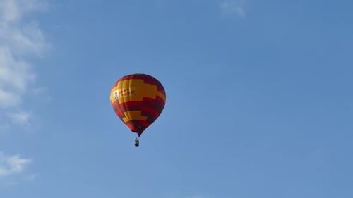 Hot Air Balloon Gently Floats in Blue Sky