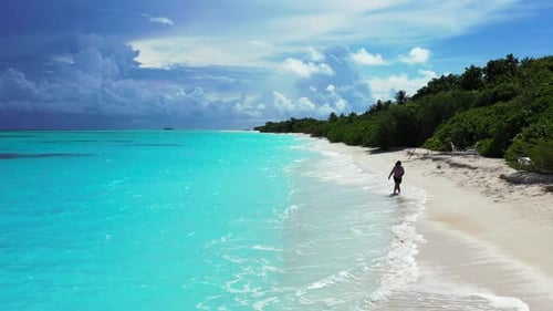 Lady alone posing on tranquil coastline beach adventure by shallow ocean and white sand background o