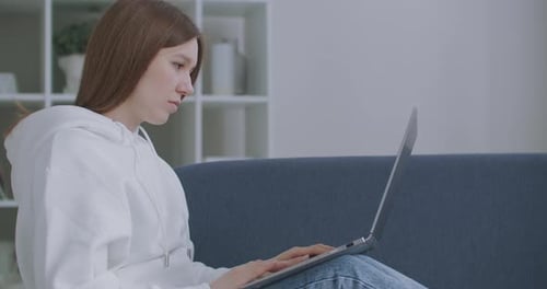 Young Woman Working on Laptop Computer at Home