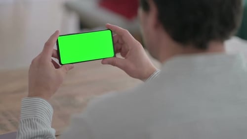 Man Holds Phone with Green Screen