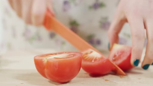 Hands Slice Fresh Red Tomato into Wedges