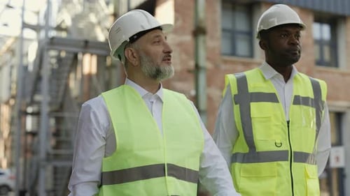 Engineers Review Plans at Construction Site