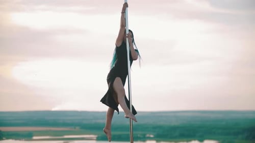 Mujer con trenzas azules bailando junto al poste - Muestra trucos