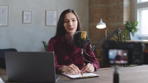 Beautiful Woman Filming Vlog with Digital Camera in Studio