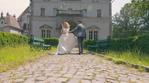 Young Wedding Couple in Love Newlyweds Walking in a Fabulous Sunny Park on a Background of Green