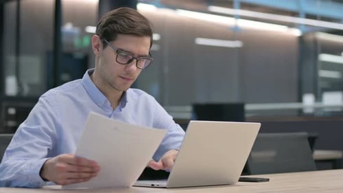 Young Adult Working on Laptop in Office