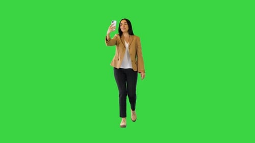 Young Indian Girl Walking and Making a Video Call on a Green Screen Chroma Key
