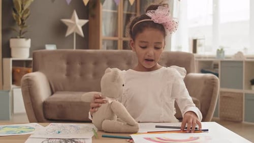 Girl Draws with Teddy Bear in Cozy Home