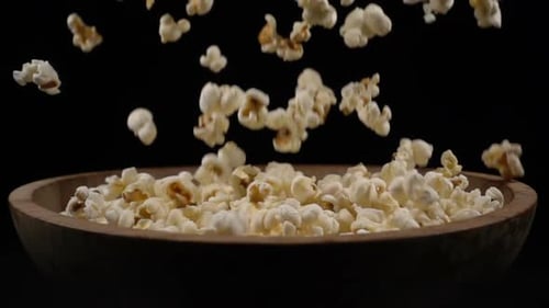 Popcorn Falls Into a Wooden Bowl