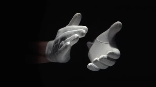Handschuhte Hände klatschen auf schwarzem Hintergrund Nahaufnahme