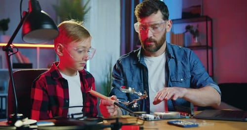 Boy and Man Working on Tech Project Together